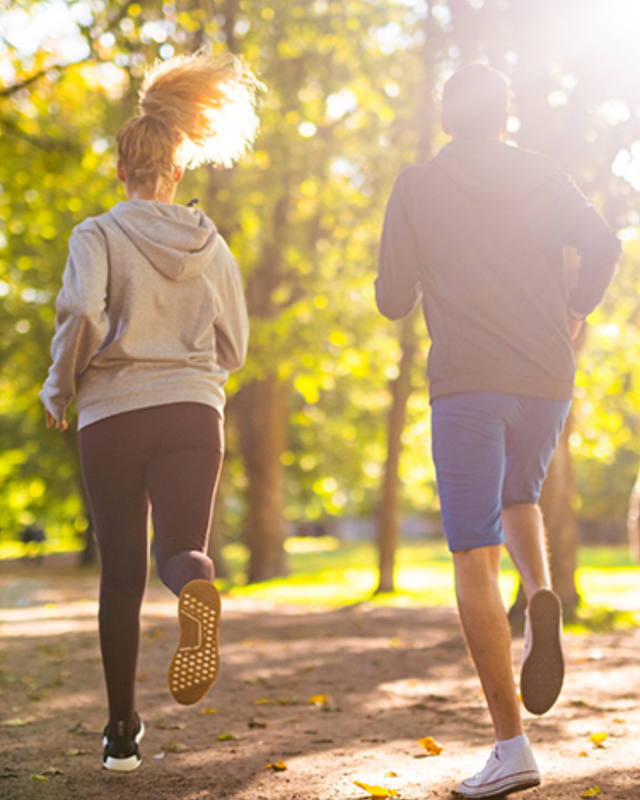 Deux personnes faisant du jogging dans un parc, vues de l'arrière.
